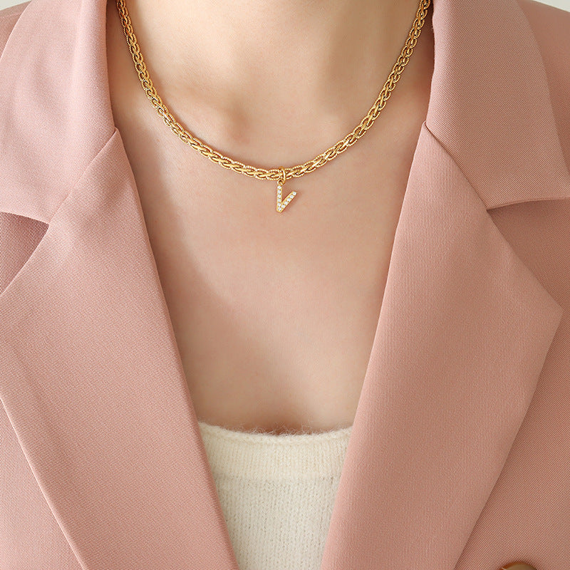 Collar con colgante de letra de circonita con incrustaciones de latón