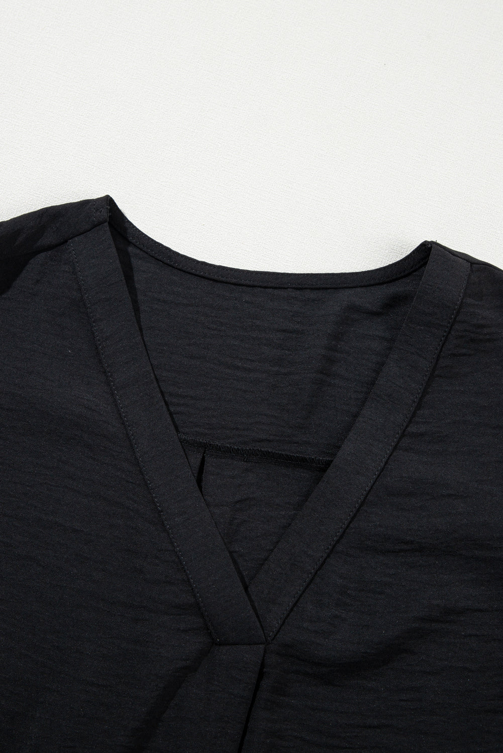 Blusa negra con cuello en V y mangas cortas con volantes en talla grande