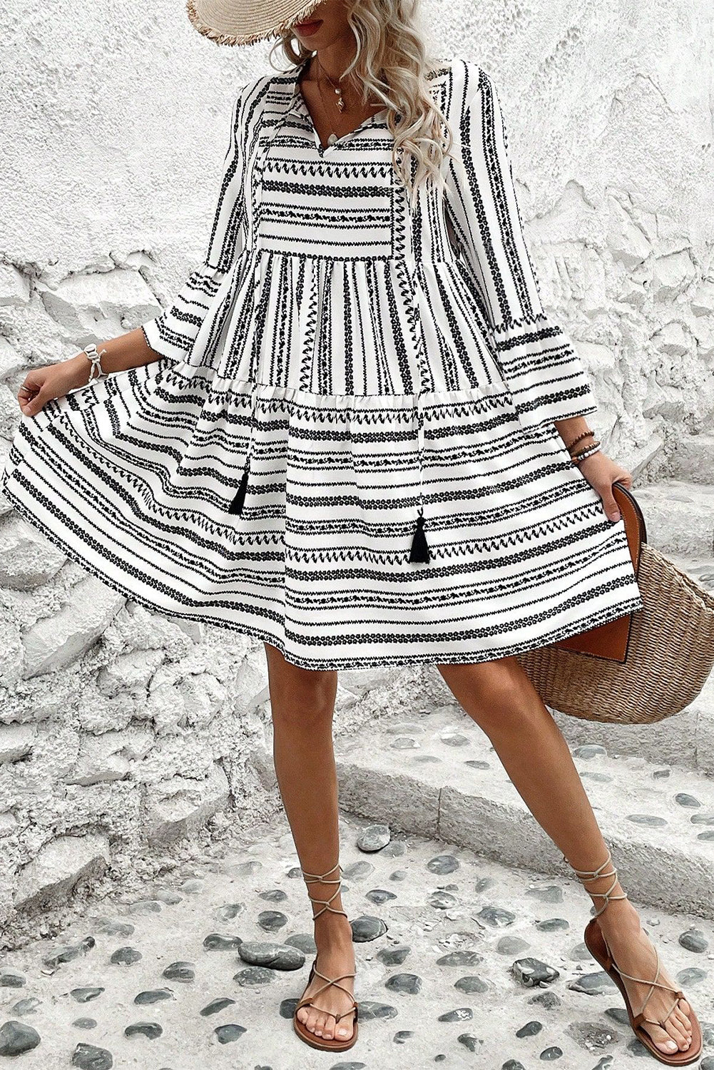 Vestido corto con escote en V, mangas acampanadas, cuello con lazo y flecos a rayas negras