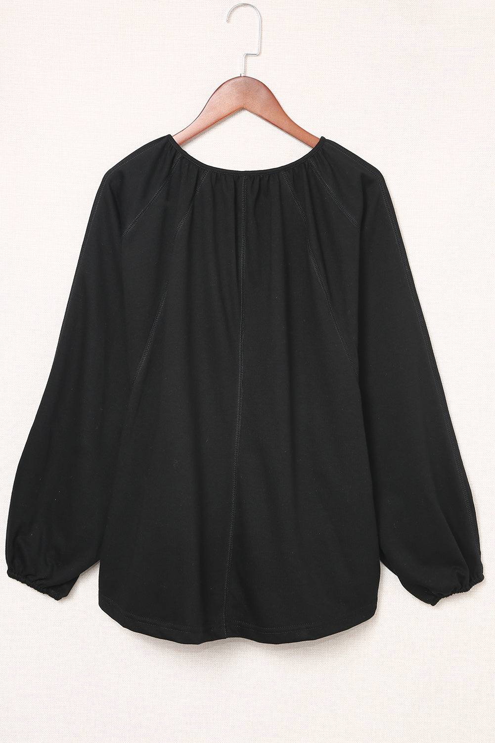 Blusa negra informal con escote en V y detalle plisado