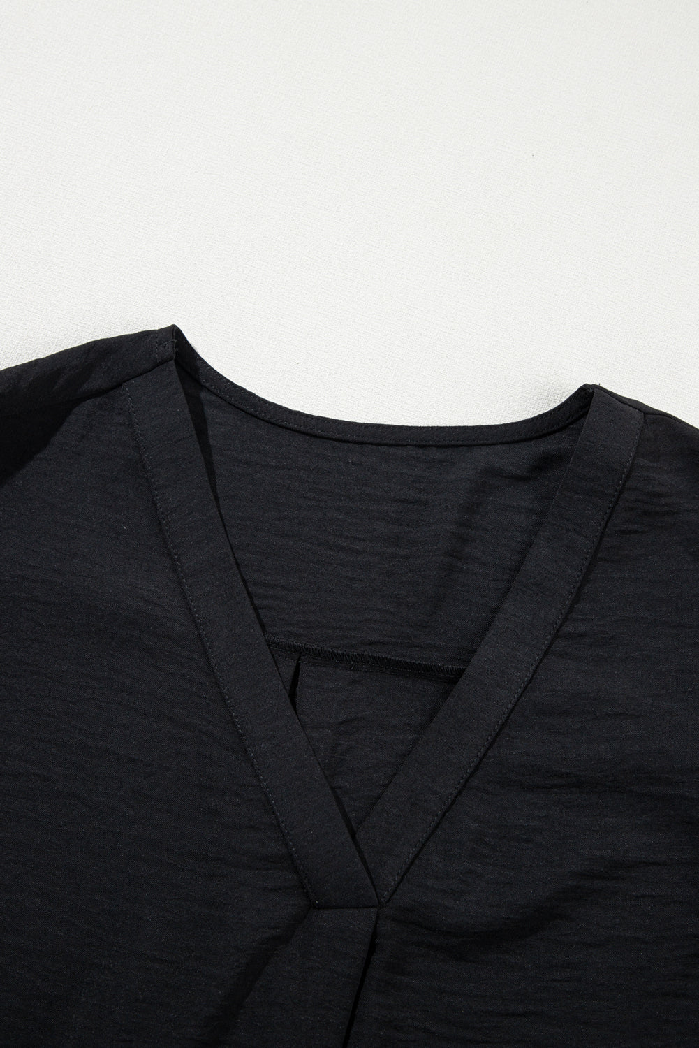 Blusa negra con cuello en V y mangas cortas con volantes en talla grande