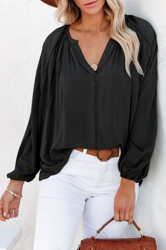 Blusa negra informal con escote en V y detalle plisado